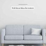 Wall decor ideas for renters featuring leaned canvas art, adhesive-hung frames, and a large floor mirror in a warm neutral apartment